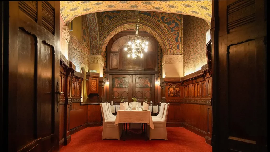 Kaisernische mit Kronleuchter, gemusterter Decke und rotem Teppichboden