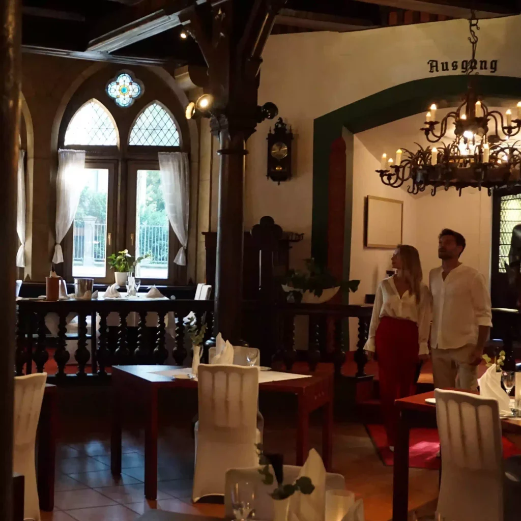 Historisches Restaurant mit Holzvertäfelung, Kronleuchtern und gedeckten Tischen