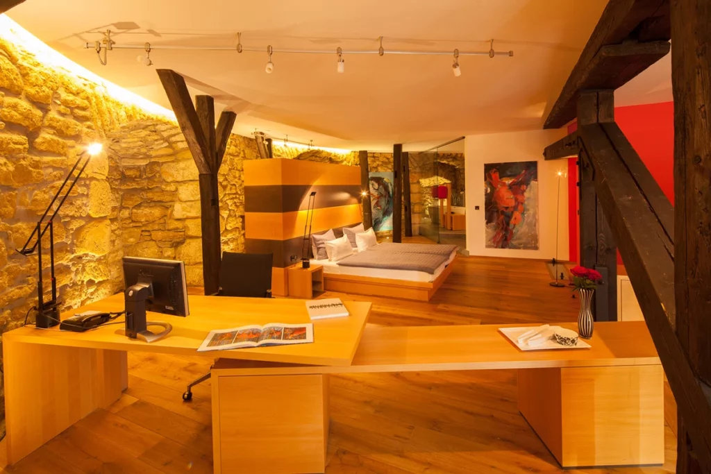 Gemütliches Hotelzimmer mit Holzboden, Doppelbett und Schreibtisch