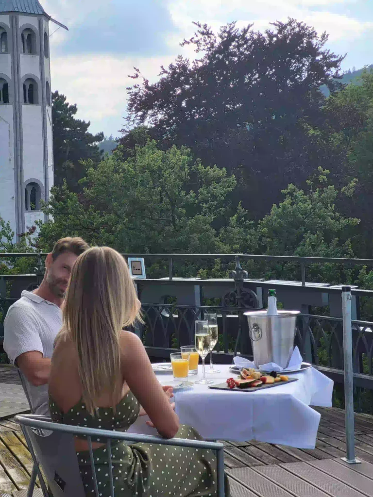 Paar genießt Dinner auf Balkon mit Blick ins Grüne