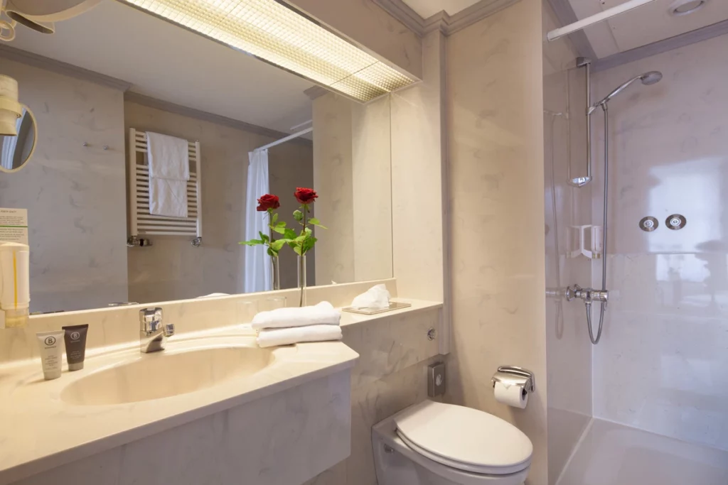 Helles Badezimmer mit Dusche und großem Spiegel