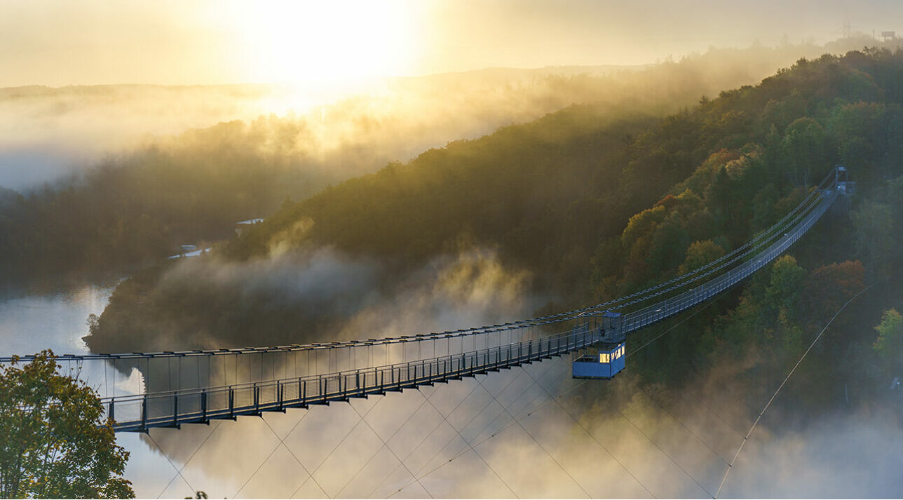 Gondel fährt über einen Fluss umgeben von Wolken und Nebel